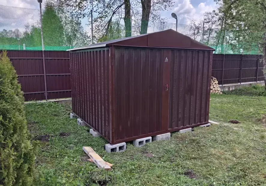 Хозблок SKOGGY коричневого цвета RAL 8017 на дачном участке